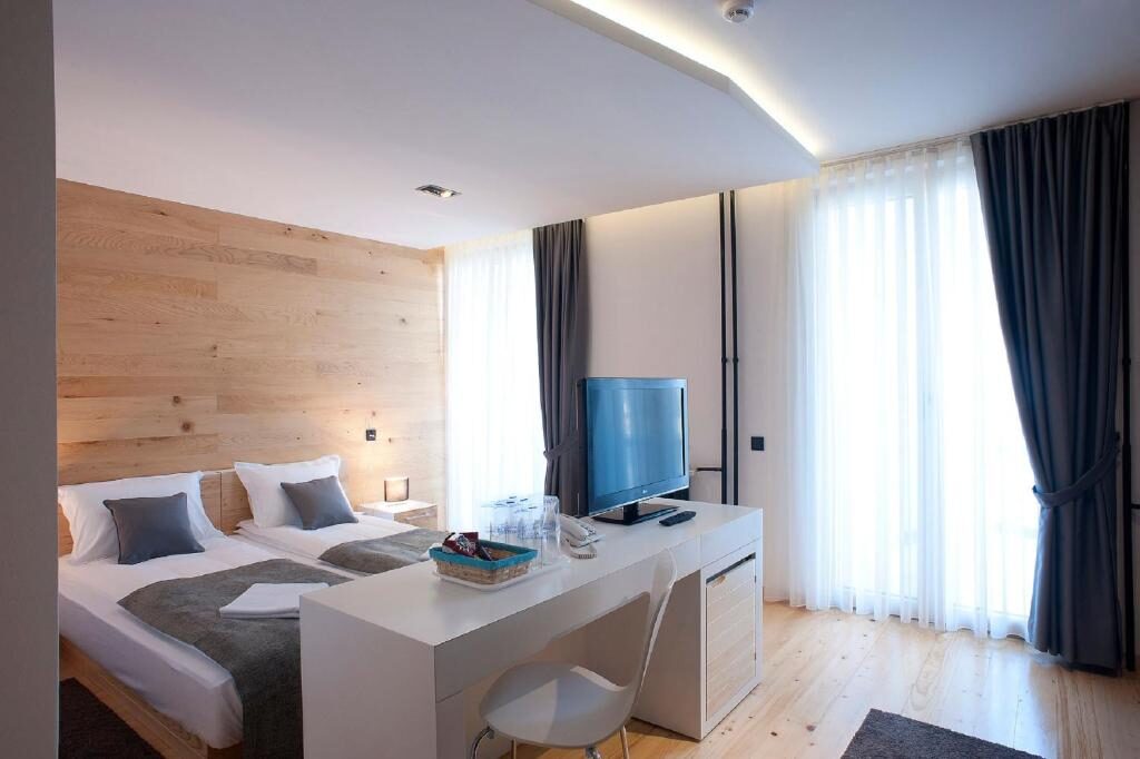 Guest room with desk, balcony window and wooden wall